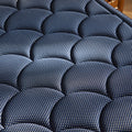 Close-up view of the DreamCloud Luxe signature navy blue scalloped quilted cover designed for maximum breathability and plush comfort.
