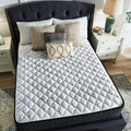 Top view of Ashley Sierra Sleep 12 Inch Plush Mattress on a stylish tufted bed with decorative pillows.

