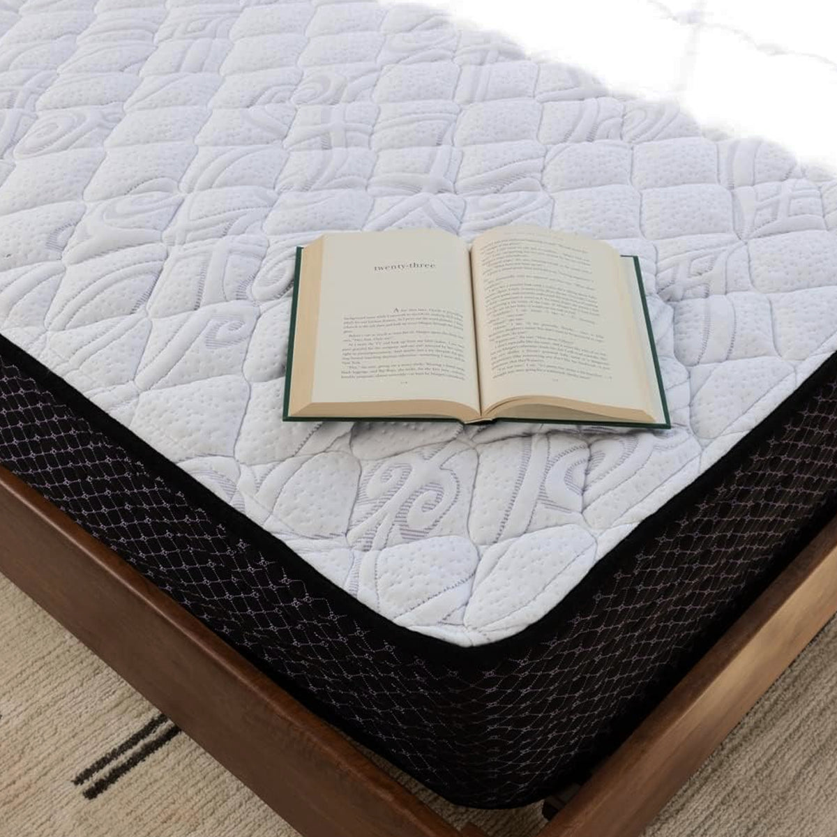 Close-up of the breathable quilted top of a Sierra Sleep 12 Inch Plush Mattress with a book for scale.
