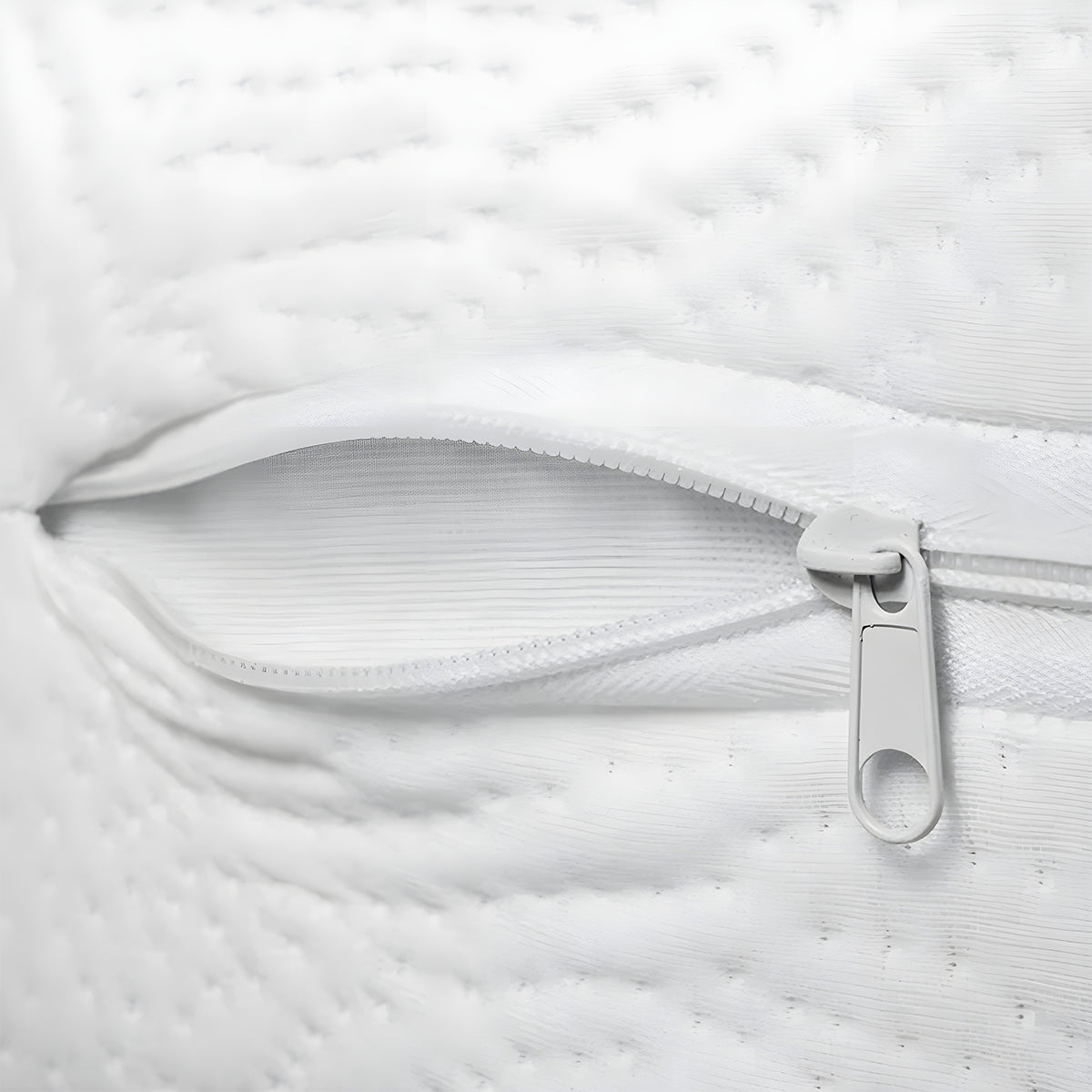 Detail of an open zipper on an organic mini crib mattress showing the breathable inner layers.