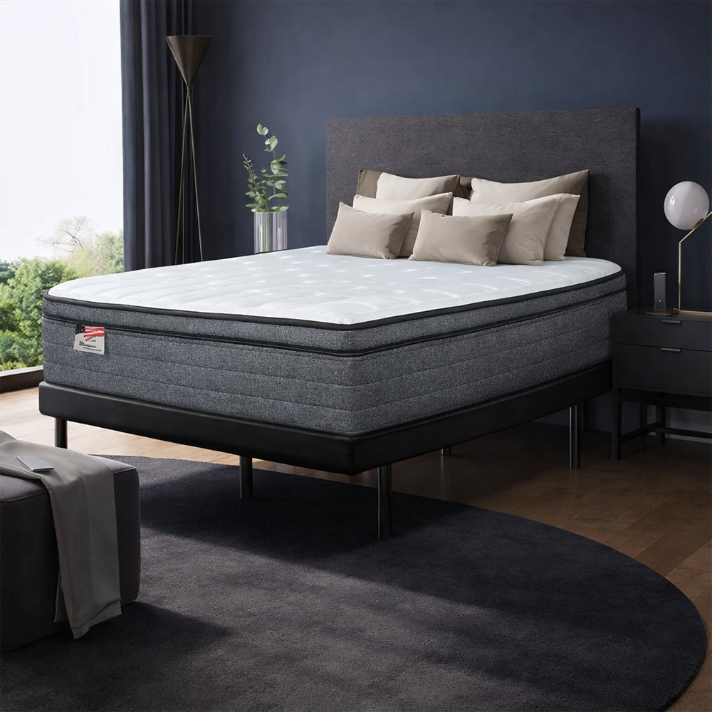 Modern bedroom setup featuring the Aria 12-inch firm mattress by Americanstar on a black platform bed frame with a designer headboard.
