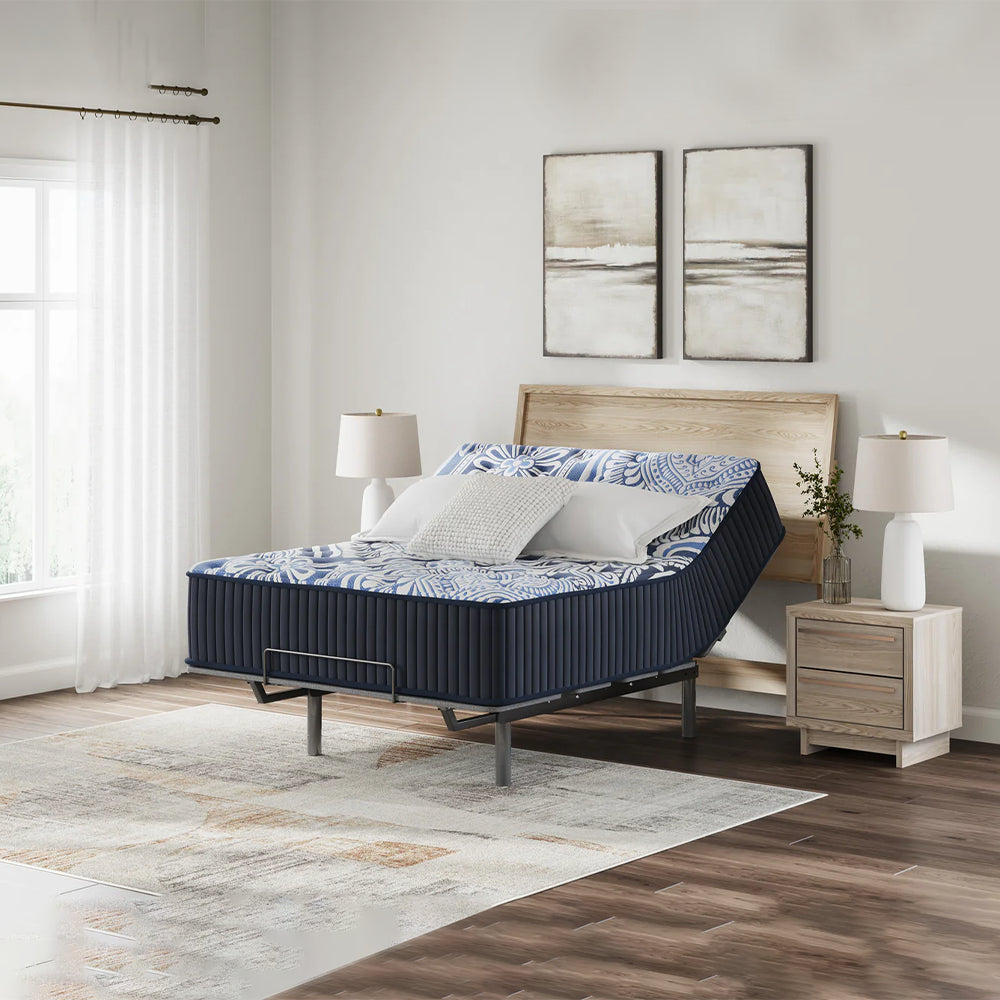Ashley Luxe 2.0 Blue mattress with the head section raised on an adjustable base in a luxury minimalist bedroom setting.
