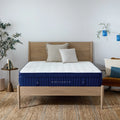 Full frontal view of the Weekender 11-inch Euro Top Hybrid mattress styled on a natural wood platform bed in a bright, modern master bedroom.
