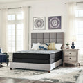 Comfort Plus 10 Inch Medium Mattress in a bedroom setting with modern art and light grey upholstered furniture.