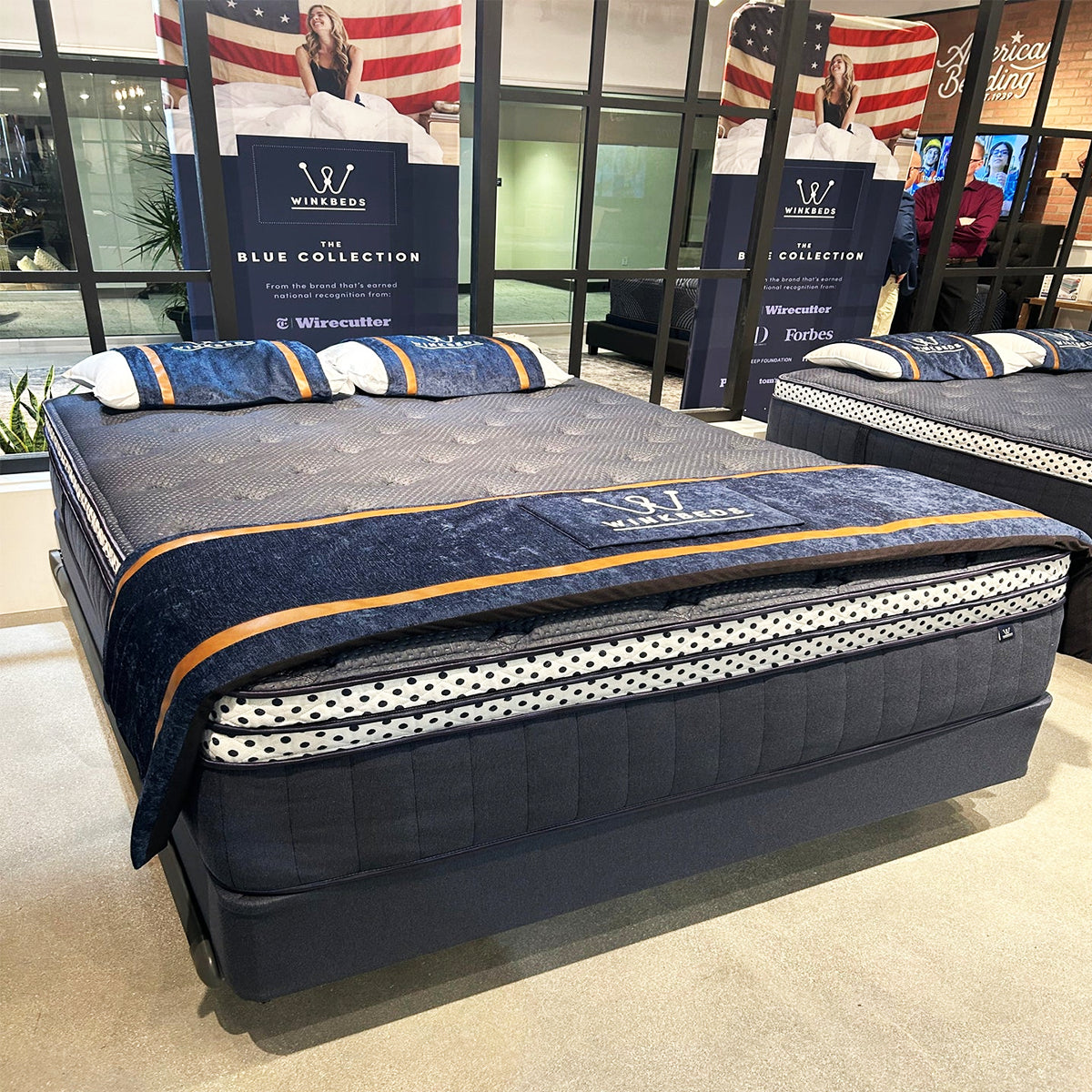 Retail display of the WinkBeds Blue 17" Mattress collection featuring luxury firm wrapped coil technology.