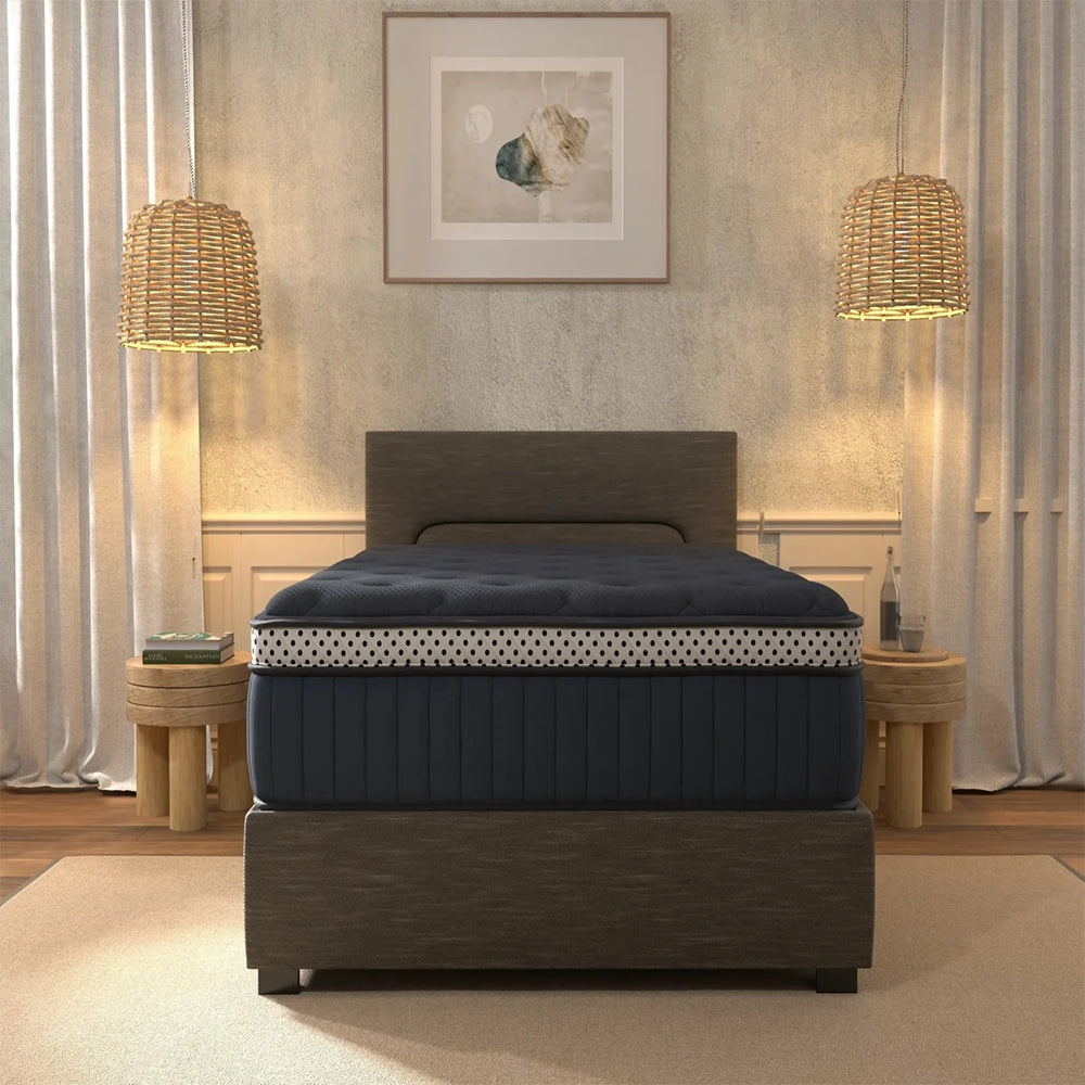 Luxury master bedroom featuring the navy blue WinkBeds Blue 15-inch mattress on a charcoal grey upholstered bed frame with designer lighting.
