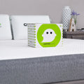GhostBed hypoallergenic mattress protector box on a bed, providing breathable, 10-year warranty protection.
