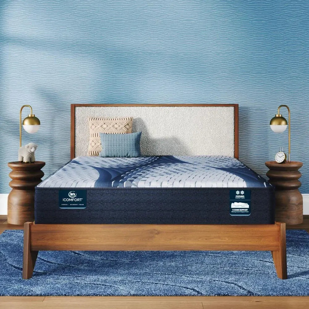 Serta iComfort Aveda Plush 12 inch mattress in a modern blue bedroom on a wooden bed frame.
