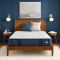Serta iComfortPRO Quilted Chelsea 12 inch medium mattress on a wooden bed frame in a modern blue bedroom.
