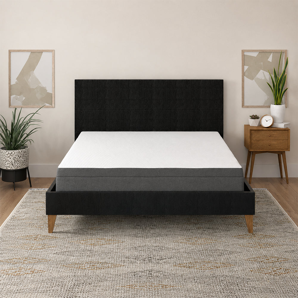 Centered view of the South Bay Daisy 8-inch mattress in a minimalist master bedroom setting with neutral decor and a grey patterned rug.
