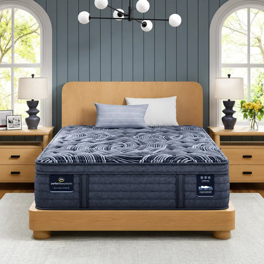Serta Perfect Sleeper Pro Valais 15 inch latex hybrid plush pillow top mattress on a wooden bed frame.
