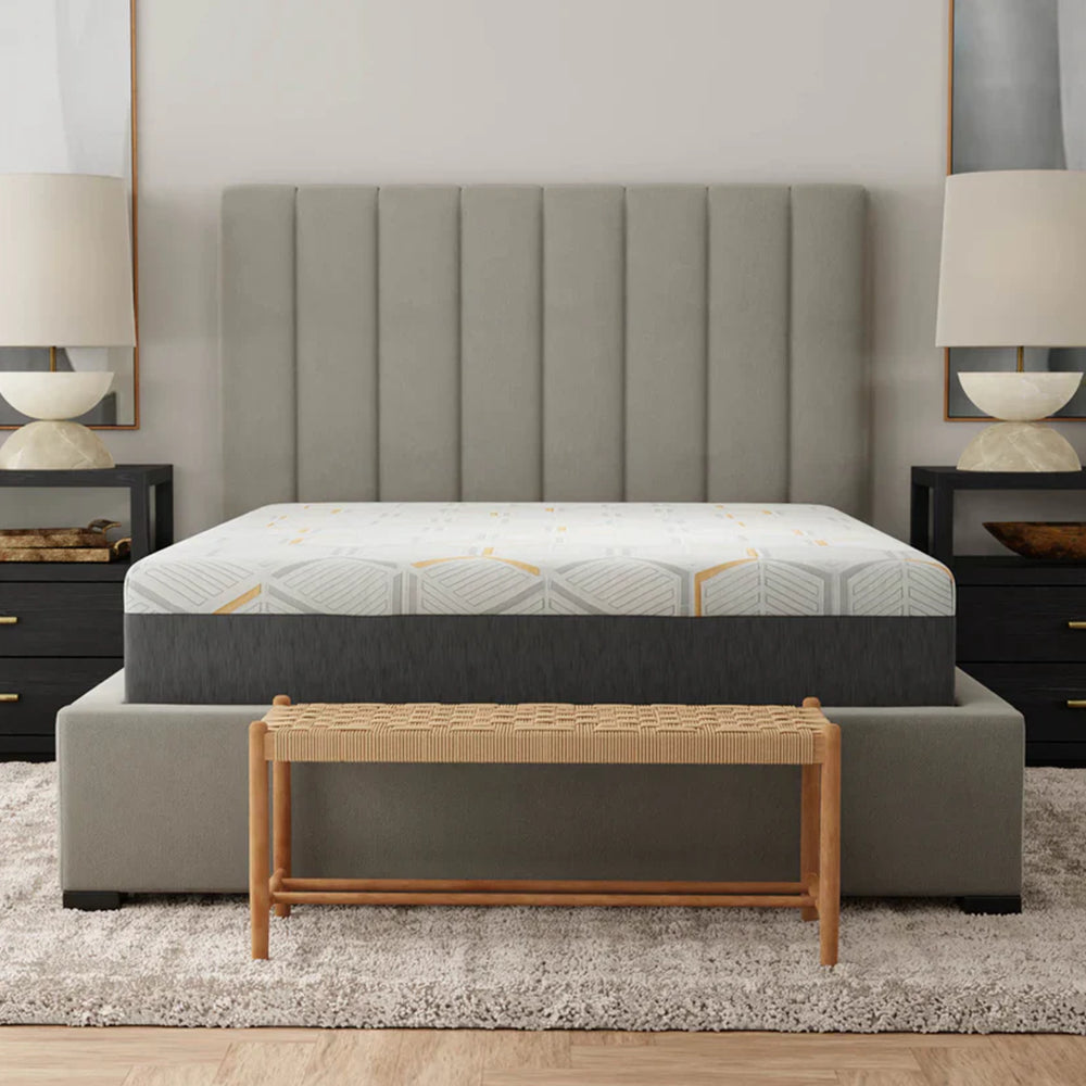 Front view of the South Bay 12-inch Copper Gel Infused Medium Firm Mattress on a stylish platform bed with a tall vertical-tufted grey headboard.
