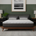 Front view of the South Bay Essentials 10-inch gel-infused memory foam mattress on a walnut platform bed frame in a modern bedroom with green walls.
