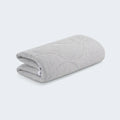 Folded light gray Air-X crib mattress protector by BEDGEAR with soft, quilted moisture-wicking fabric.
