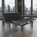 Customatic Dreamsense the Synergy adjustable bed base in a modern bedroom setting with a city skyline view.
