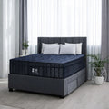 Phantom Lux 16-inch medium mattress displayed on a grey upholstered platform bed with storage drawers in a brightly lit modern bedroom.
