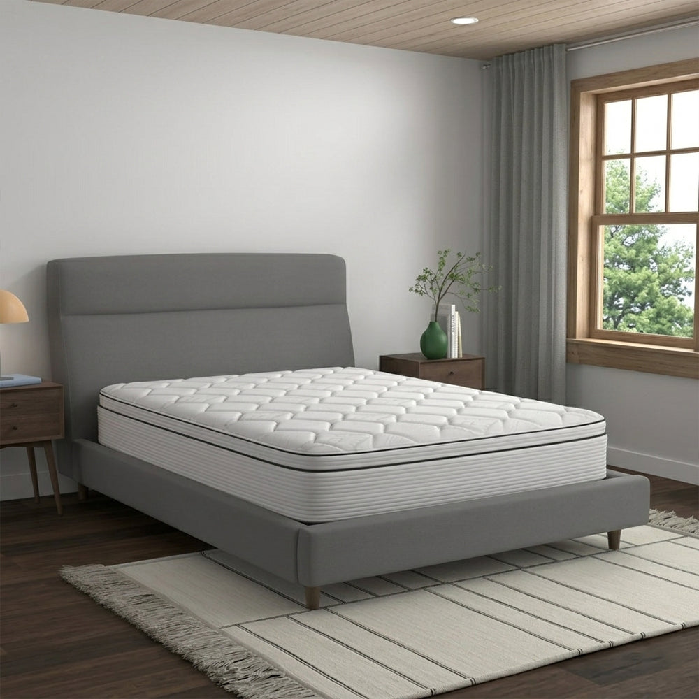 Corner angle shot of the American Bedding Cymbal Jingle 10" Hybrid Euro Top mattress in a contemporary bedroom setting for firm back support.
