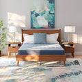 Symmetrical front-facing bedroom view of the Peak 2.0 8-inch mattress styled on a mid-century modern wooden platform bed frame.
