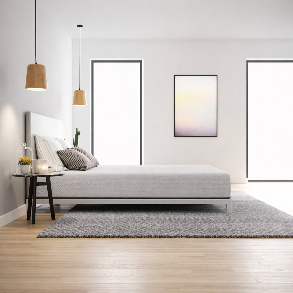 Front view of the Ease Medium Gel Memory Mattress styled with grey pillows in a bright, contemporary bedroom setting.