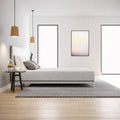 Front view of the Ease Medium Gel Memory Mattress styled with grey pillows in a bright, contemporary bedroom setting.
