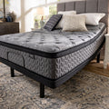 Close-up corner view of the Augusta 12 inch Firm Pillow Top Mattress elevated on an adjustable base in a bedroom.