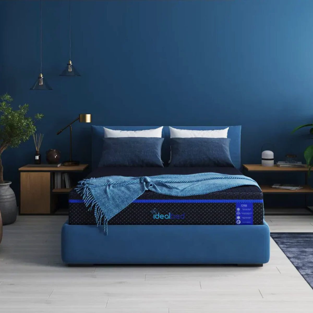S4 Nebula Luxury Hybrid Mattress in bedroom setting with a plush blue upholstered frame and deep blue walls.