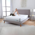 S Performance Mattress by Bedgear in a bedroom setting with a woman relaxing on the plush white top surface.