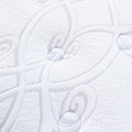 Close-up of the plush white quilted fabric and scroll pattern on the 13.5 Inch Pillow Top Mattress comfort surface.