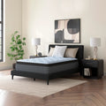 The Destin Cove 15-inch ultra plush mattress by Ashley styled in a bright bedroom, highlighting the blue geometric quilted cooling cover.
