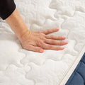 Close-up hand pressure test demonstrating the contouring gel memory foam and medium-plush responsiveness of the GhostBed Grande mattress.
