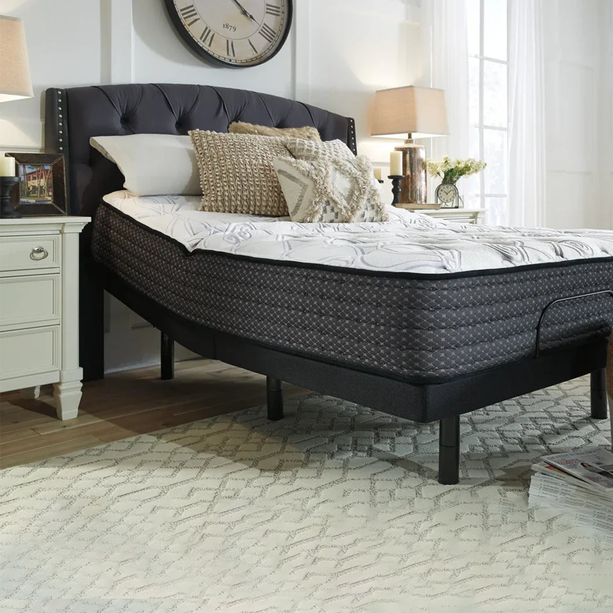 Sierra Sleep Limited Edition Firm Mattress on a grey button-tufted headboard bed frame, front view.