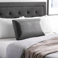 Black bamboo charcoal memory foam pillow on a bed, featuring zoned support for orthopedic neck alignment.
