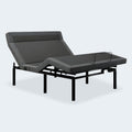 Perspective view of the iDealBed Smart 6i motorized bed frame with premium charcoal upholstery and head section elevated.
