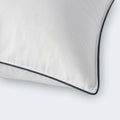 Close-up of the breathable cotton cover and durable navy piping on a SleepTone Loft down-blend pillow.