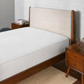 Close-up of a BEDGEAR Ver-Tex mattress protector on a wooden bed frame, featuring breathable cooling technology.
