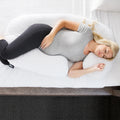 Pregnant woman using a Malouf wrap-around body pillow for ergonomic back, belly, and hip support while sleeping