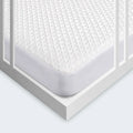 Close-up of the BEDGEAR Ver-Tex cooling crib mattress protector with a secure, snug fit for baby's safety.
