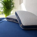 Stacked Cosmo performance pillows showing different lofts for side, back, and stomach sleepers on a blue bed.