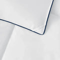 Close-up of the elegant navy blue piped detail on the SleepTone Tranquility duck down comforter.
