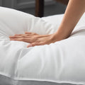 Hand pressing into a Malouf gelled microfiber pillow showing its plush, responsive feel and loft.
