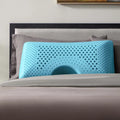 Blue Malouf Shoulder pillow with zoned technology on a bed for ergonomic neck support and pressure relief.
