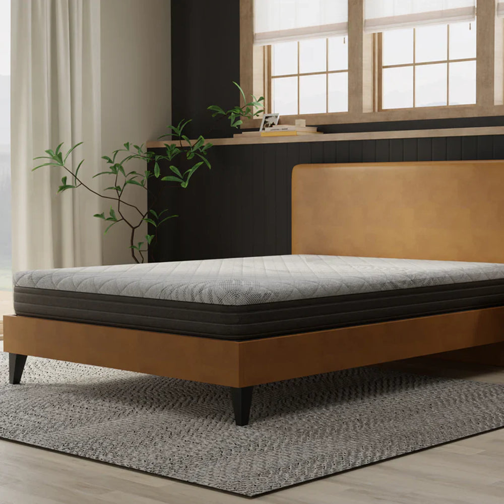 Three-quarter angle of the South Bay Essentials firm 8-inch mattress highlighting the grey quilted top and dark grey base on a stylish platform bed.
