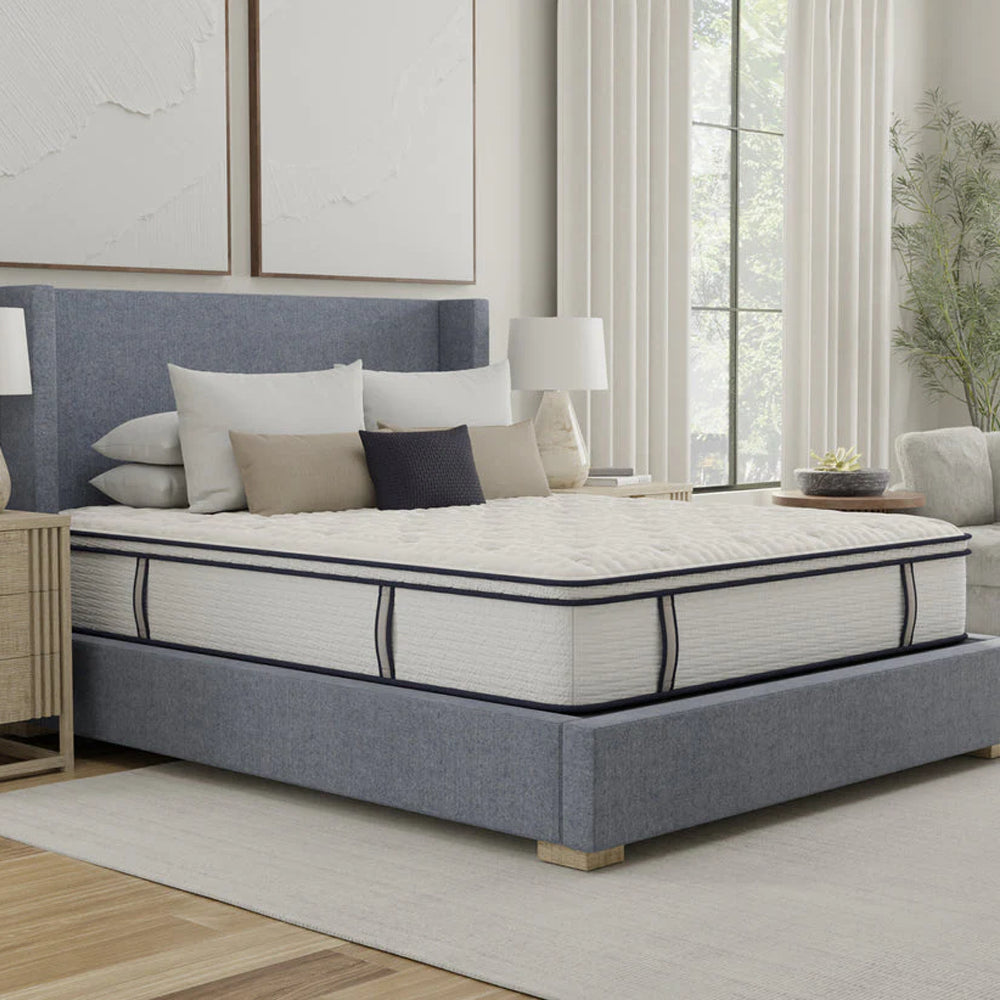 Three-quarter angle of the Sofinity Hybrid Signature 12-inch mattress highlighting the thick Euro top and premium navy blue piping.
