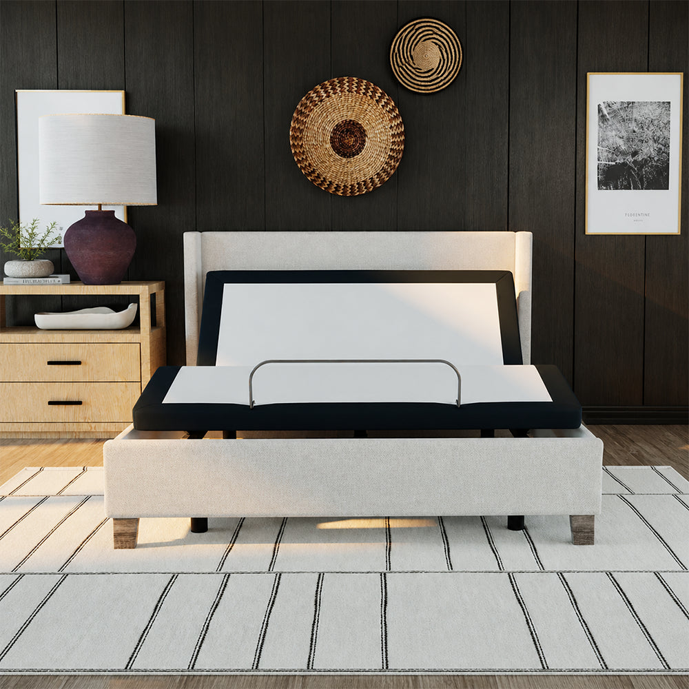 Front view of the SBKD3 zero-clearance adjustable base fitted inside an upholstered bed frame, showing the head-up position for reading or lounging.

