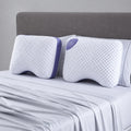 Two BEDGEAR Balance Cuddle Curve pillows propped on a bed, providing ergonomic neck and shoulder alignment.
