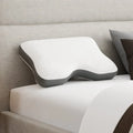 Ergonomic South Bay contoured shoulder pillow on a bed with a shoulder cutout for side sleeper comfort and alignment.
