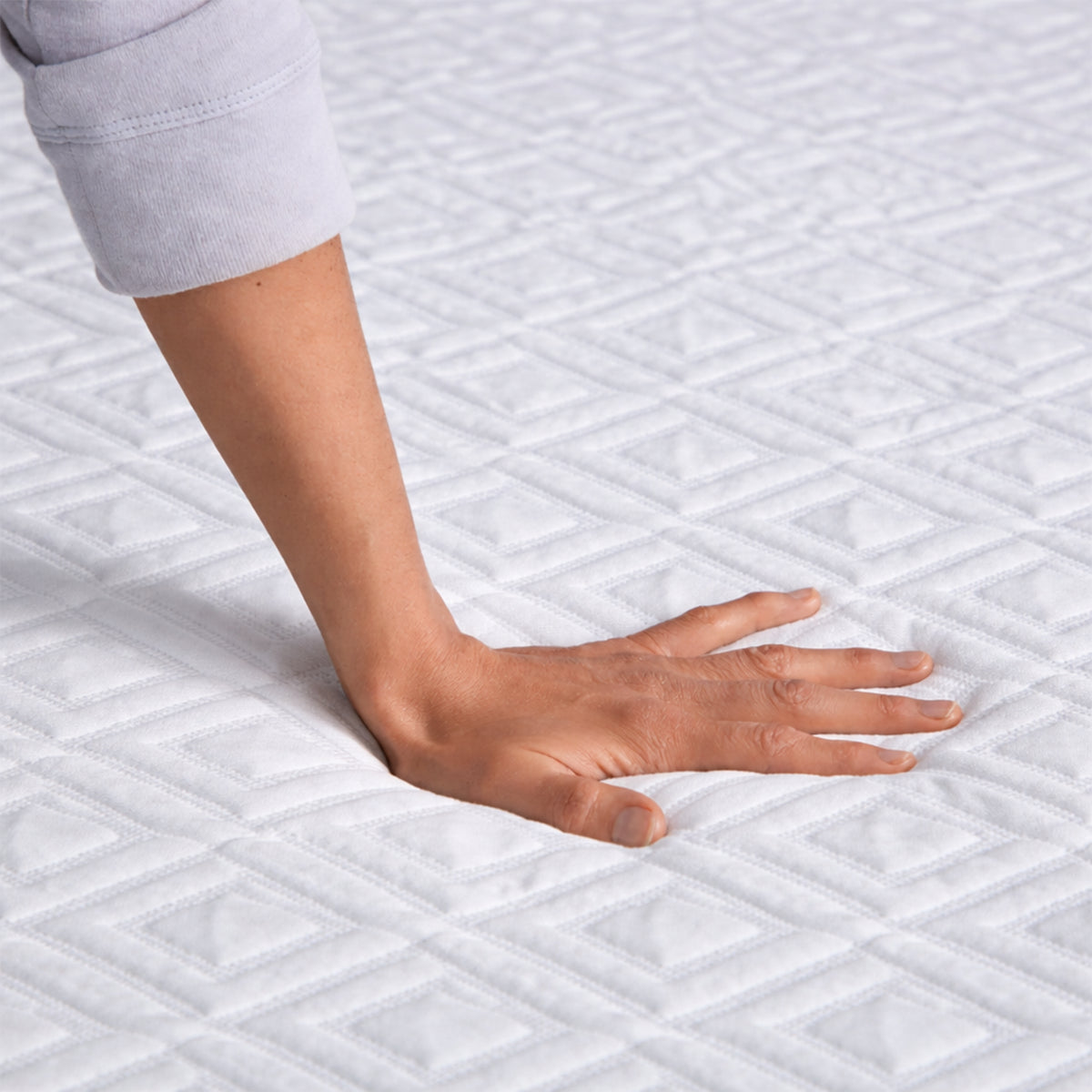 Hand pressing into the Gel Memory Foam Mattress Topper to demonstrate soft contouring and pressure relief.