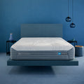 Bedroom setting featuring the H6 Hybrid Performance Mattress on a floating platform base within a modern blue room.