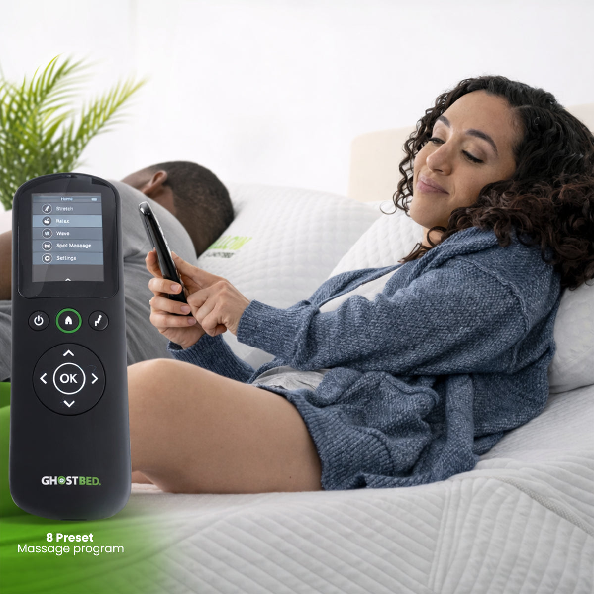 Handheld remote for the GhostBed Massage Mattress with 8 preset massage programs in a bedroom setting.