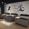 Retail showroom display of the Tommie Copper Sleep System mattresses featuring branded wall graphics for athlete recovery.
